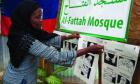 In this Sept. 28 photo, Darlene Derosier, 43, a Muslim, posts a how-to sign on the Islamic tradition of washing parts of the body (ablution) in preparation for prayer at the Al-Fattah Mosque in Gressier, Haiti. (AP)